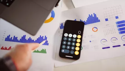 a calculator sitting on top of a table next to a laptop