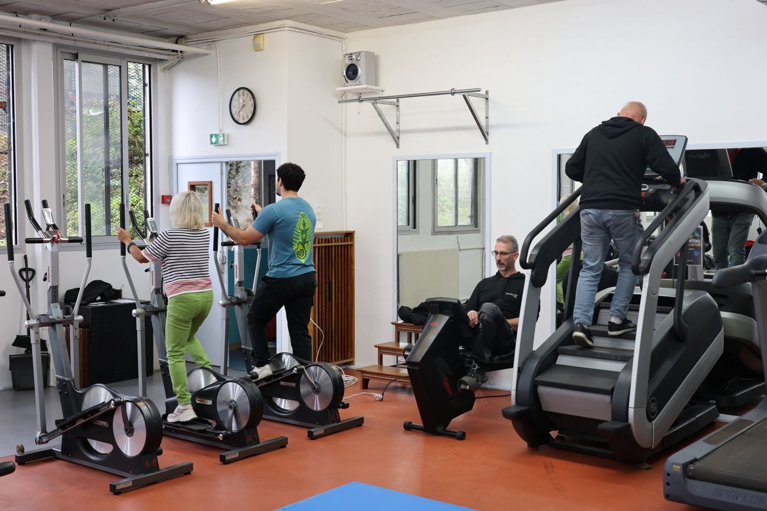 Plusieurs personnes s'entrainant sur du matériel de remise en forme.