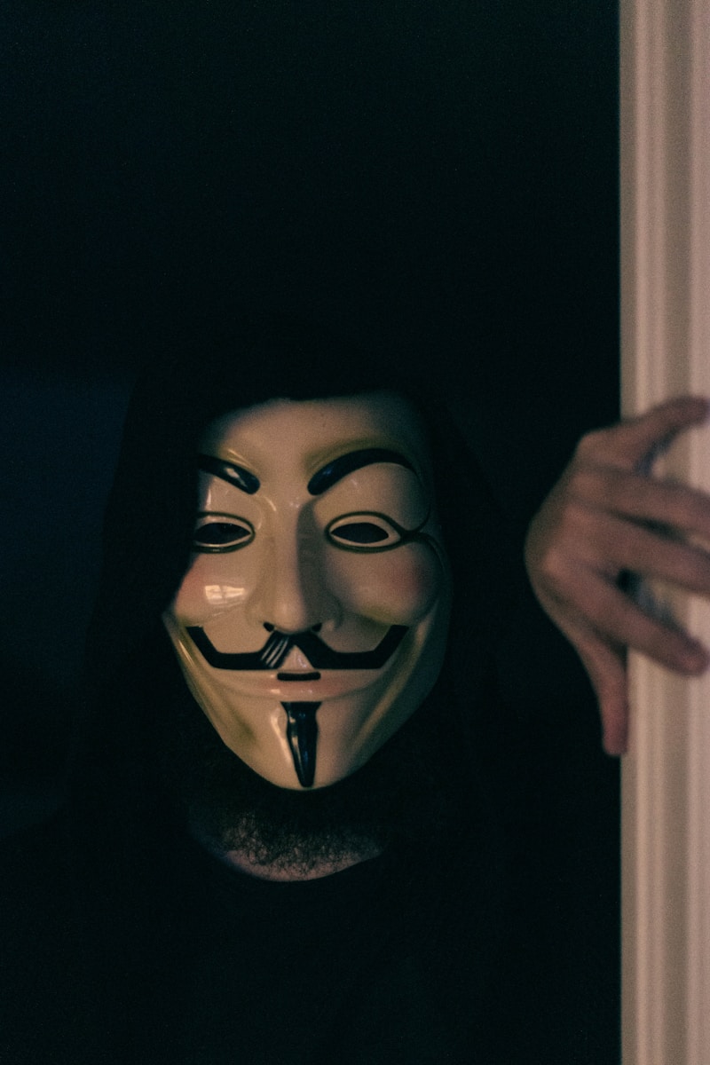 a person wearing a mask and holding a door